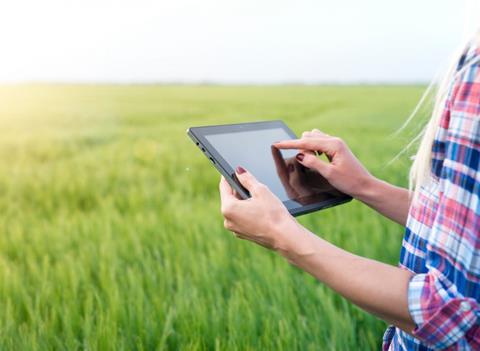 Woman holding tablet in field